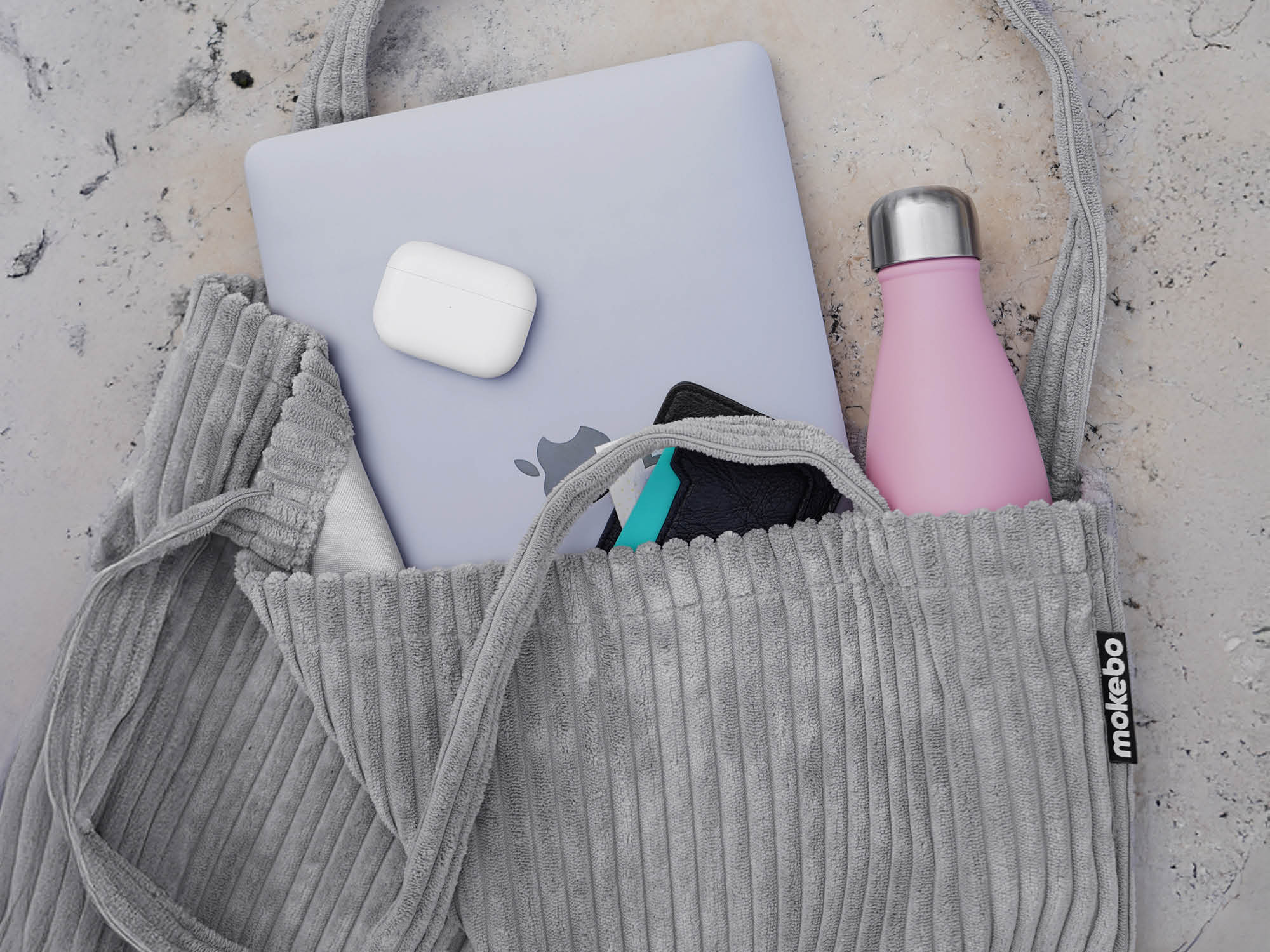 Cordtasche Tote Bag Jutebeutel in hellgrau auf einem stein Boden, Laptop Kopfhörer Flache schauen aus Tasche heraus